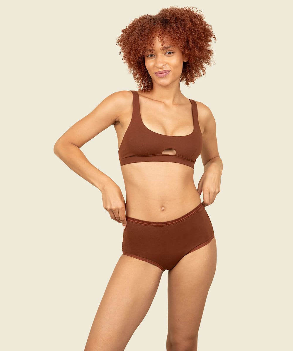 Woman in organic cotton mid-rise retro brief and keyhole soft bra in cacao brown color.