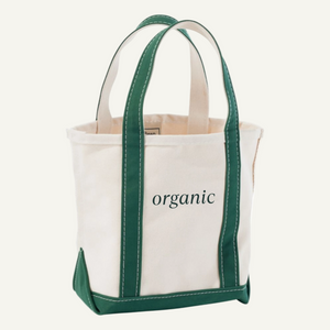 Tote bag with green handles and trim, featuring the word 'organic' on a light beige background.